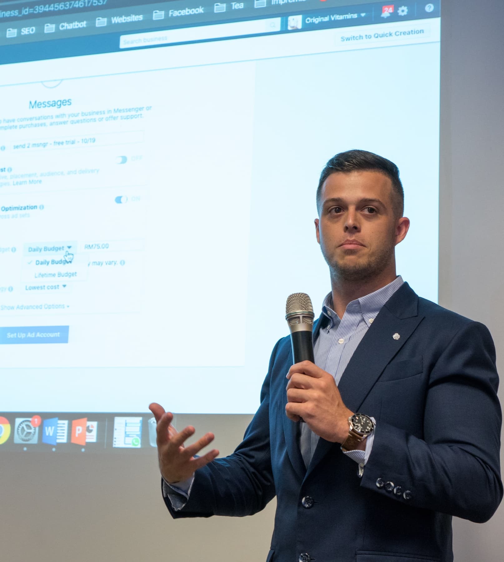 Jordan Glickman presenting at a workshop with a Facebook Ads Manager dashboard projected behind him